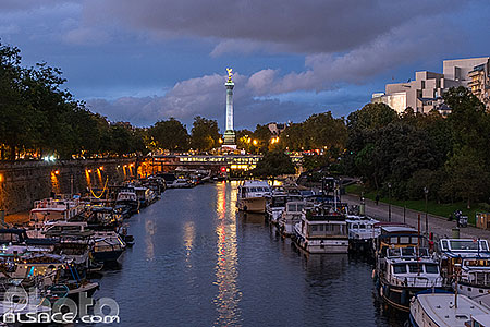 Photo : Bassin de l'Arsenal la nuit et en arrière plan la colonne de juillet de la place de la Bastille, Paris (75004)
