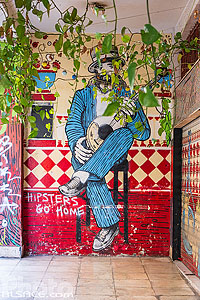 Photo : Fresque sur un mur et tag Hipsters go Home dans une rue d'Athènes, Grèce