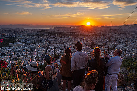 Photo : Touristes regardant le coucher de soleil sur Athènes au sommet du Mont Lycabette, Grèce