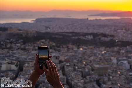 Photo : Touriste faisant une photo au smartphone depuis le mont Lycabette, Athènes, Grèce