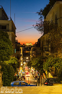 Photo : Rue d'Athènes la nuit et vue au fond sur le Parthenon illuminé au sommet de l'acropole, Grèce